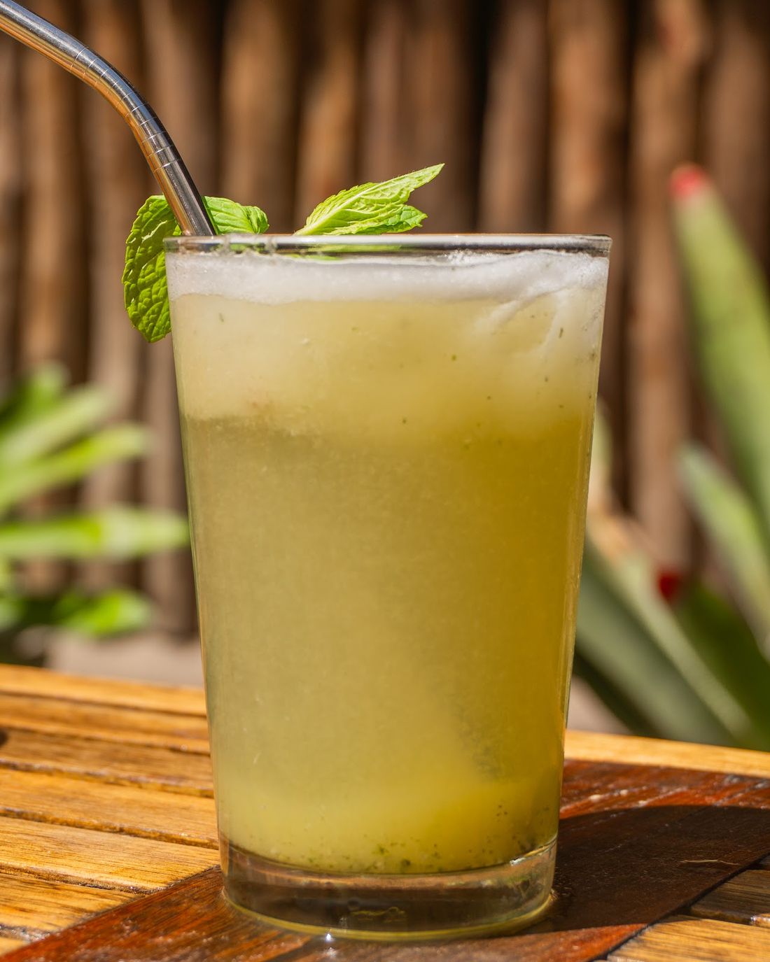 Copo de suco gelado com hortelã sobre a mesa de madeira